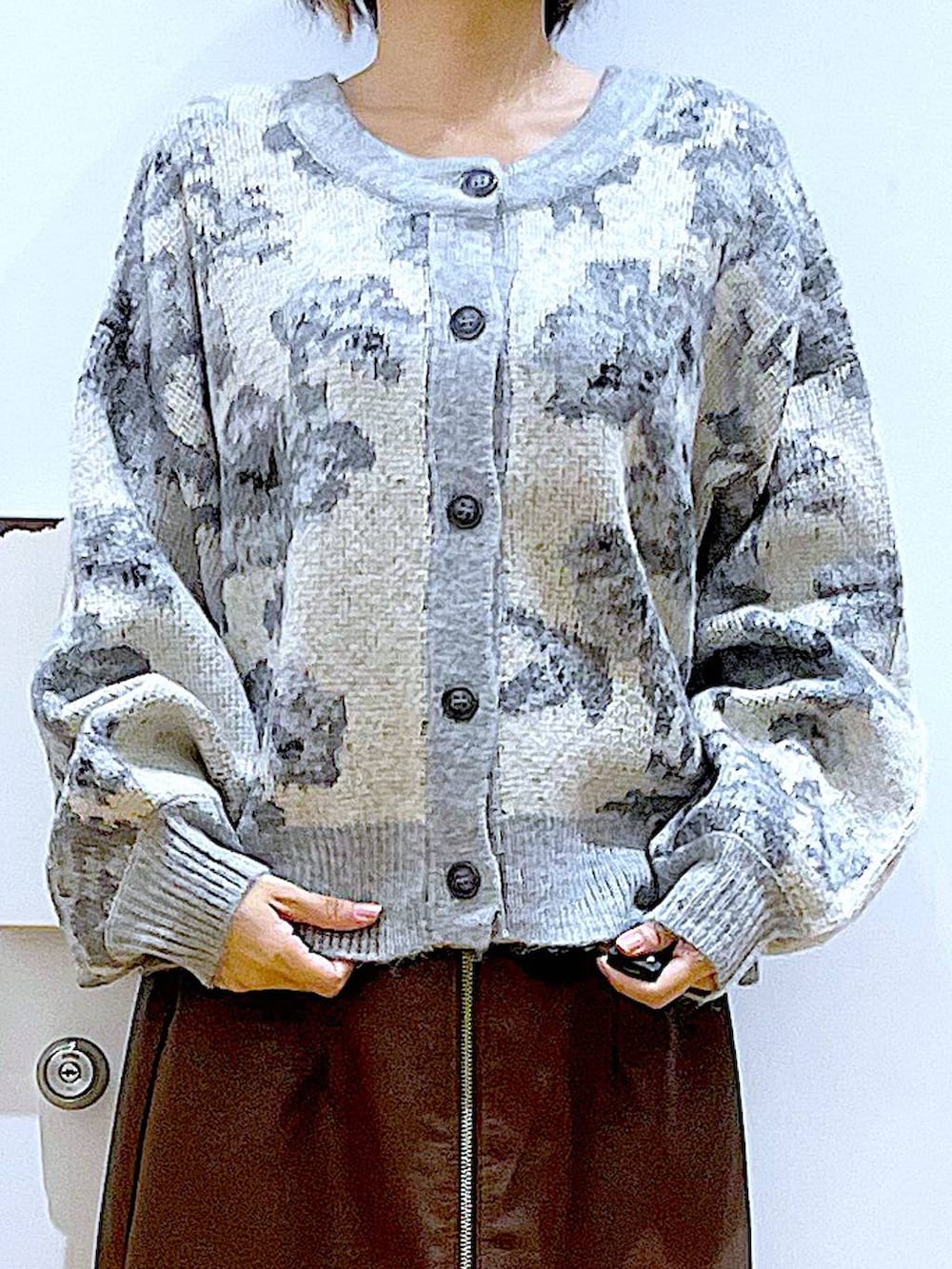 ブラウン系のスカート、ブラック系のショルダーバッグ、ブラック系のブーツを着用したレディースの冬コーディネートの7枚目の写真