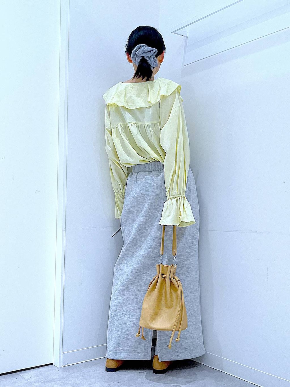 グレー系のスカート、ベージュ系のローファー、ブラウン系のショルダーバッグを着用したレディースの冬コーディネートの5枚目の写真