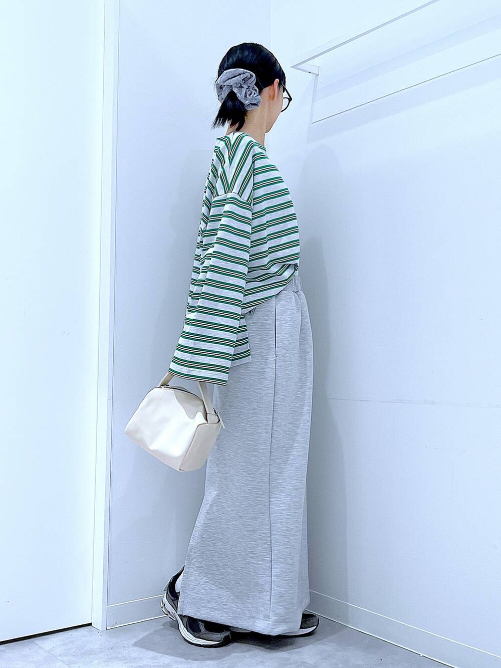 ホワイト系のショルダーバッグ、グレー系のスカート、グレー系のTシャツ/カットソーを着用したレディースの春コーディネートの4枚目の写真