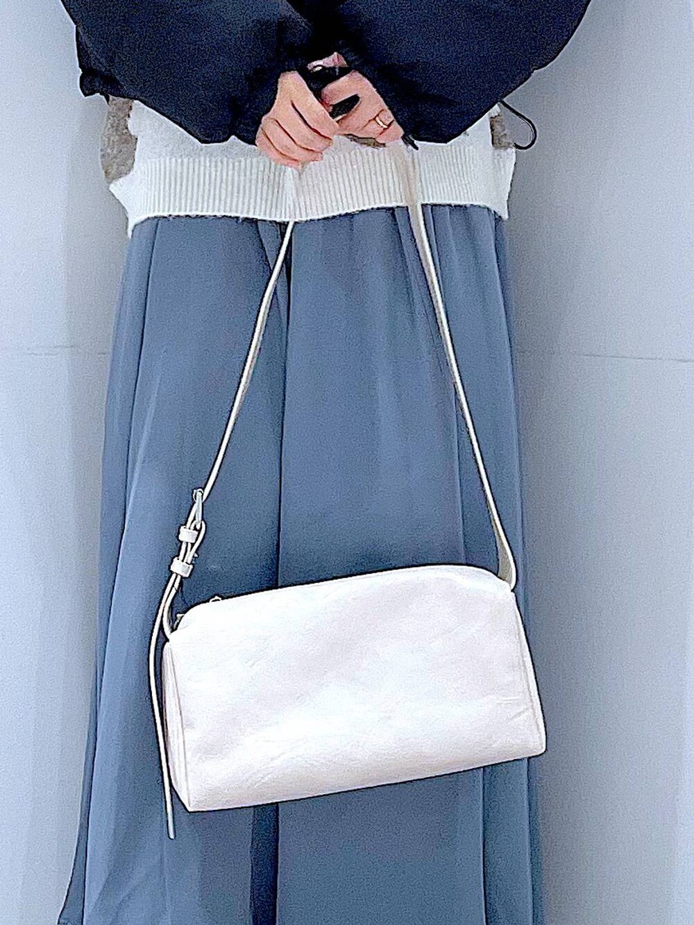 ブラック系のブルゾン、ブラック系のブーツ、ベージュ系のニット/セーターを着用したレディースの冬コーディネートの9枚目の写真