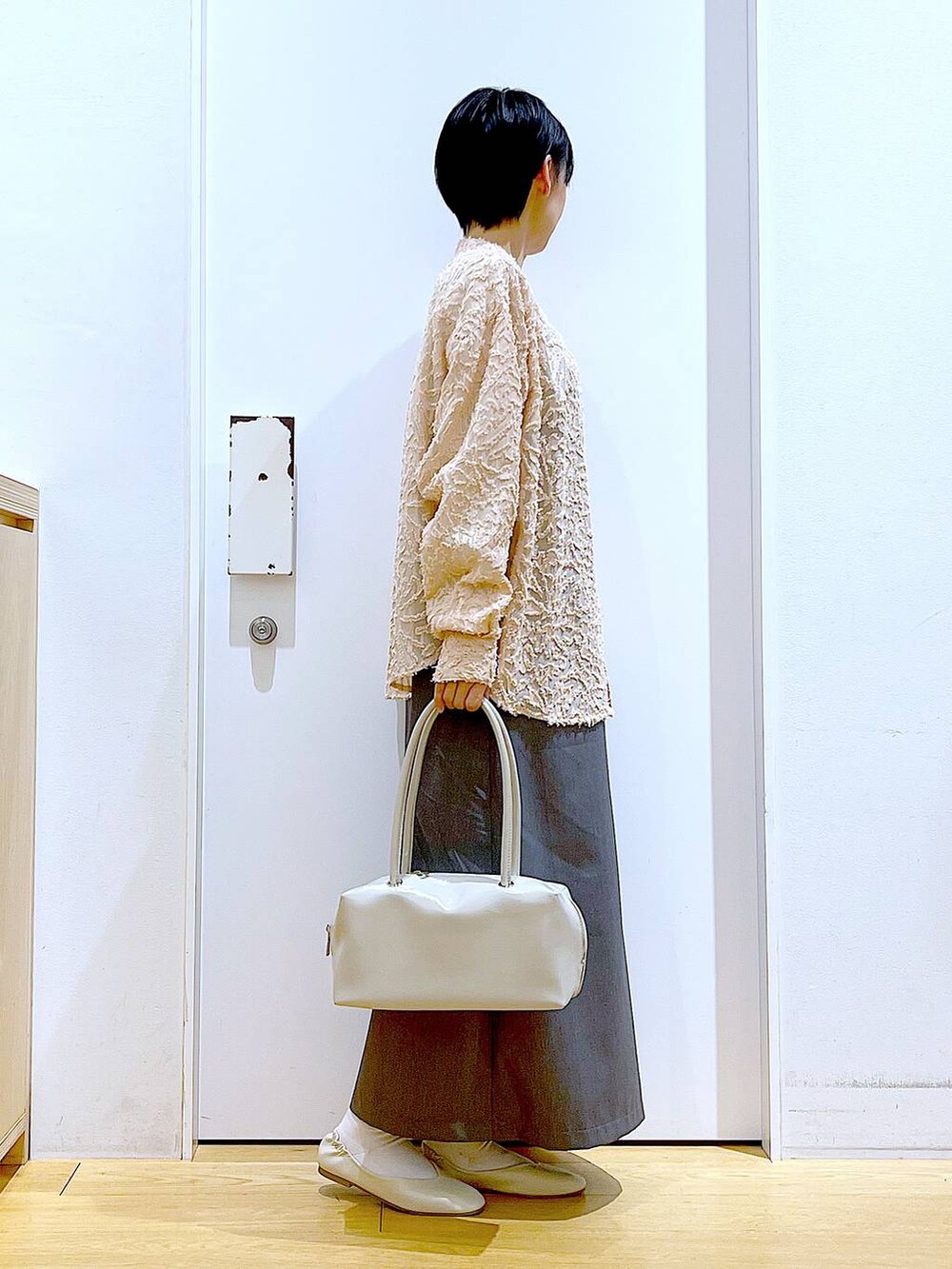 ホワイト系のボストンバッグ、ホワイト系のパンプス、ピンク系のシャツ/ブラウスを着用したレディースの春コーディネートの4枚目の写真