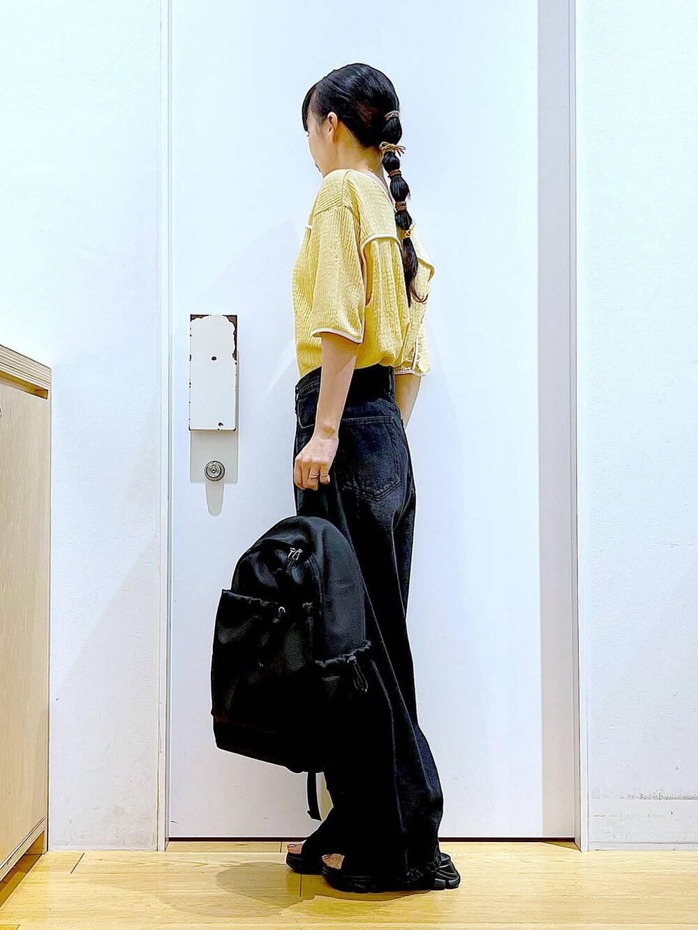 ブラック系のサンダル、ブラック系のバックパック/リュック、ブラック系のデニムパンツを着用したレディースの夏コーディネートの3枚目の写真