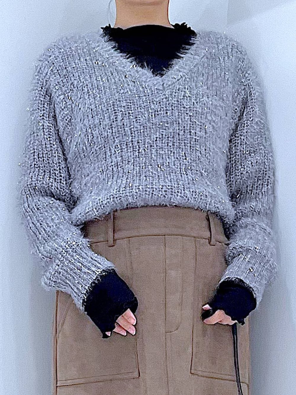 ブラック系のブーツ、ブラック系のショルダーバッグ、ブラウン系のスカートを着用したレディースの冬コーディネートの7枚目の写真