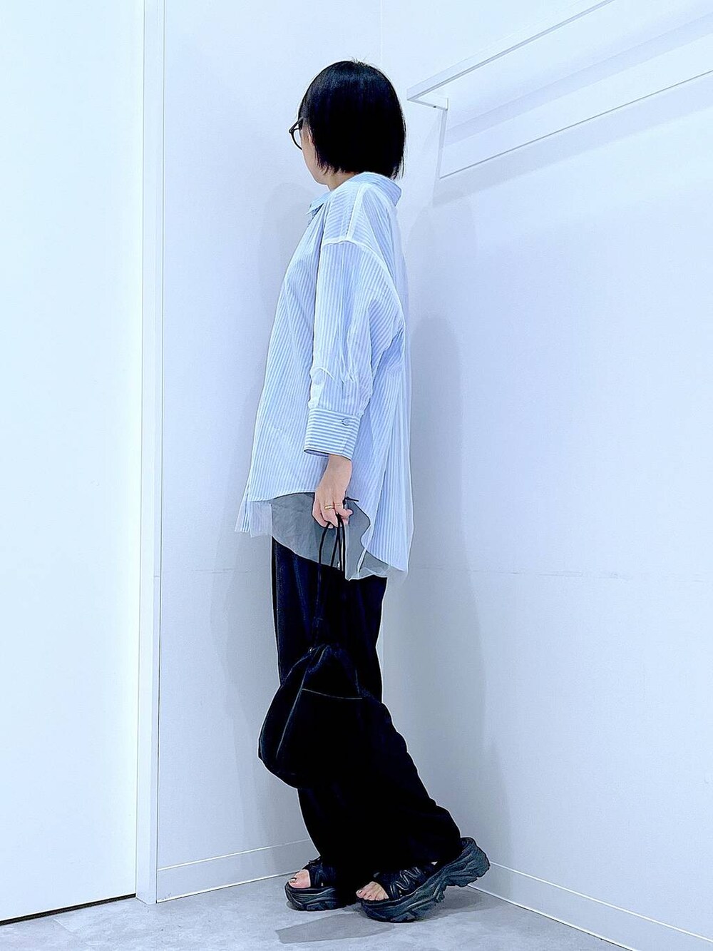 ブラック系のショルダーバッグ、ブラック系のその他パンツ、ブルー系のシャツ/ブラウスを着用したレディースの秋コーディネートの3枚目の写真