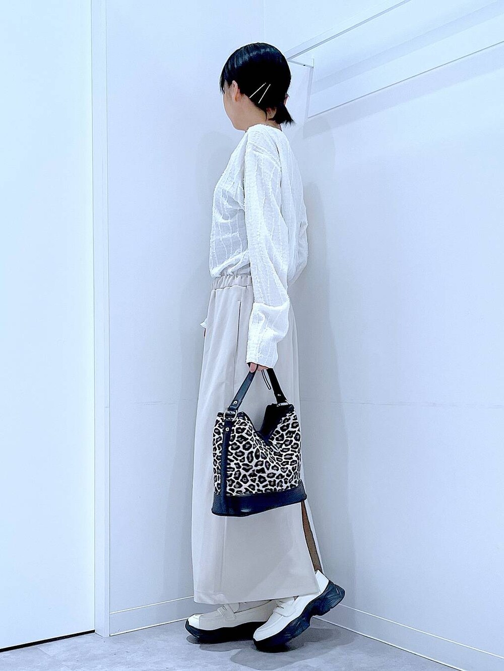 ベージュ系のスカート、ホワイト系のローファー、その他のショルダーバッグを着用したレディースの秋コーディネートの3枚目の写真