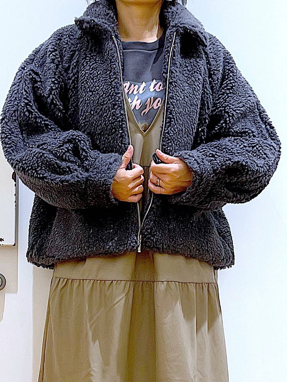 ベージュ系のショルダーバッグ、ブラック系のブーツ、ブラウン系のワンピースを着用したレディースの冬コーディネートの7枚目の写真