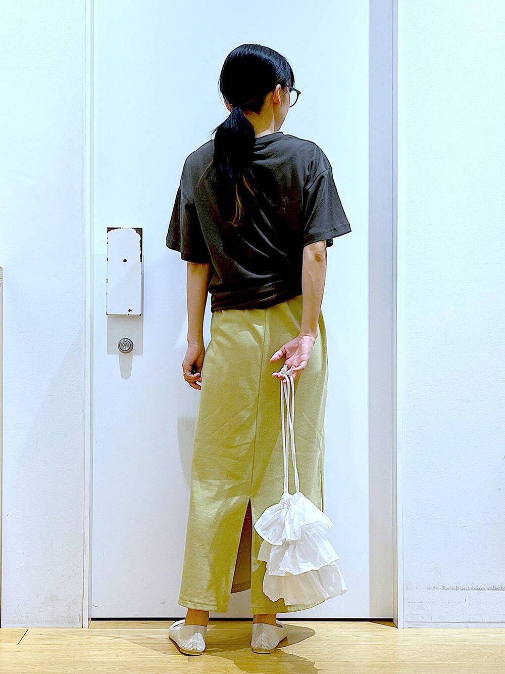 ホワイト系のショルダーバッグ、イエロー系のワンピース、ホワイト系のパンプスを着用したレディースの春コーディネートの5枚目の写真