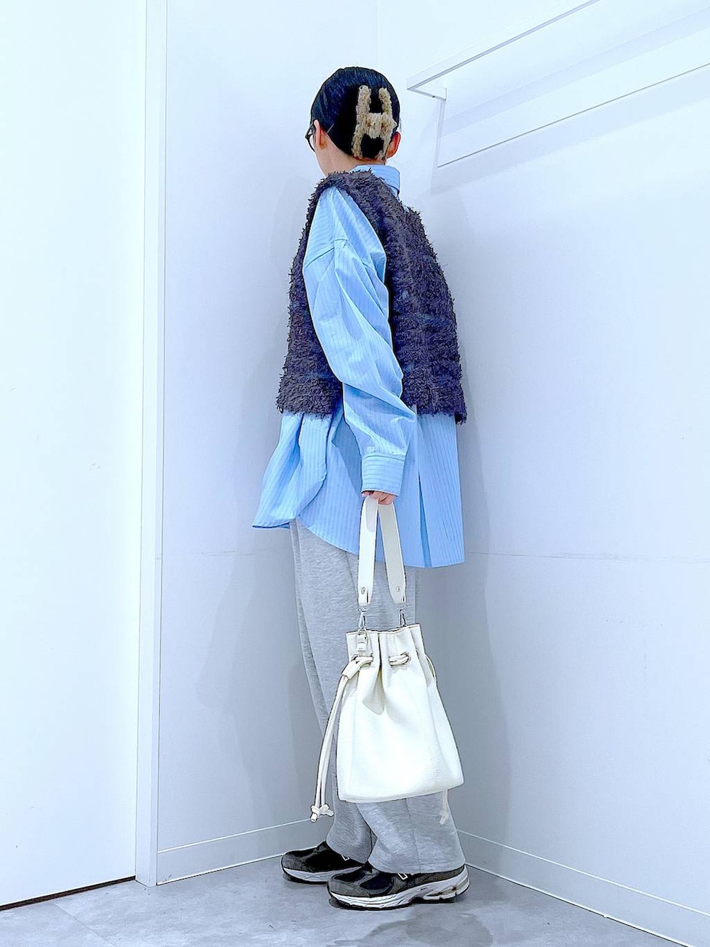 ブルー系のシャツ/ブラウス、ホワイト系のショルダーバッグ、グレー系のベストを着用したレディースの春コーディネートの3枚目の写真