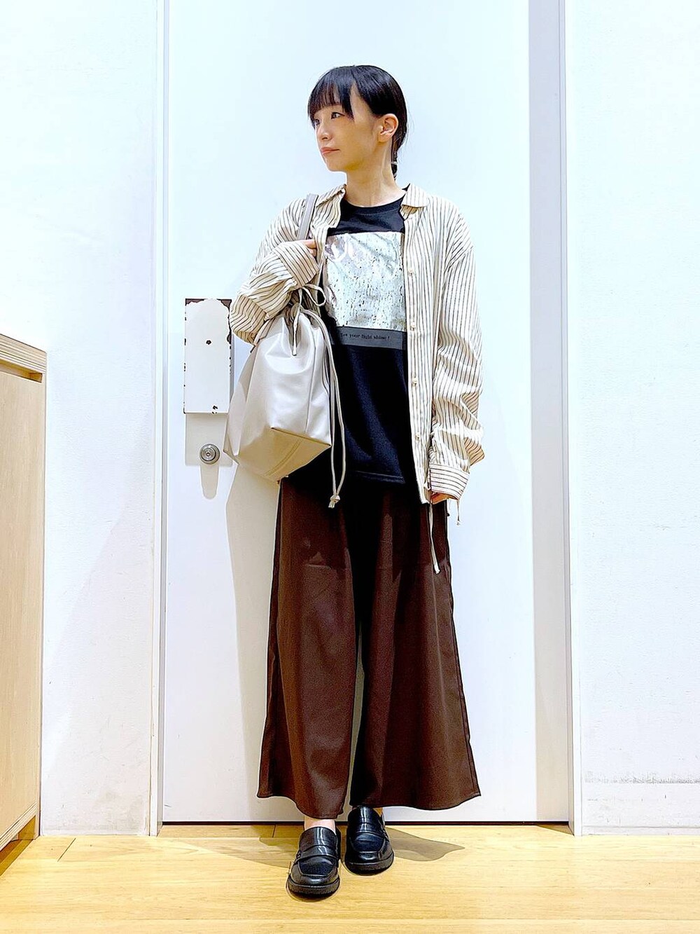 ベージュ系のトートバッグ、ブラック系のローファー、ブラウン系のその他パンツを着用したレディースの秋コーディネートの2枚目の写真