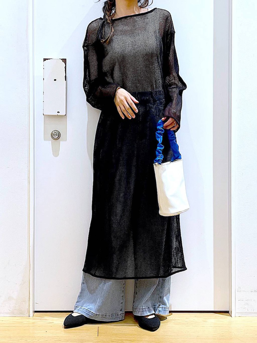 ブルー系のショルダーバッグ、ブラック系のパンプス、ブルー系のデニムパンツを着用したレディースの春コーディネートの6枚目の写真