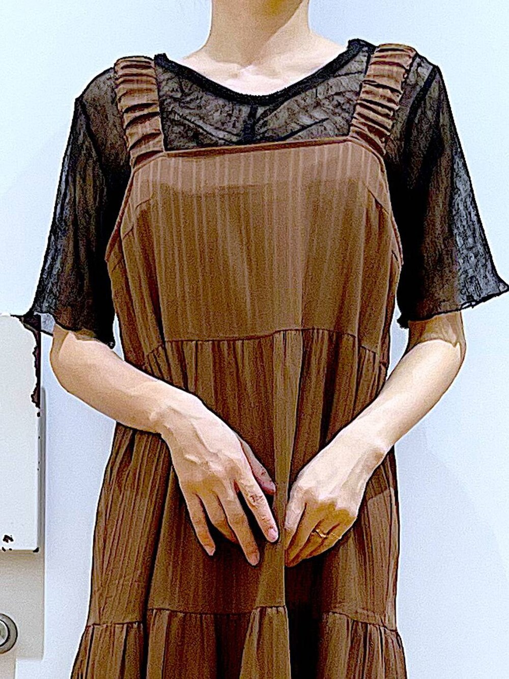 ブラック系のサンダル、ブラック系のショルダーバッグ、ベージュ系のワンピースを着用したレディースの夏コーディネートの7枚目の写真