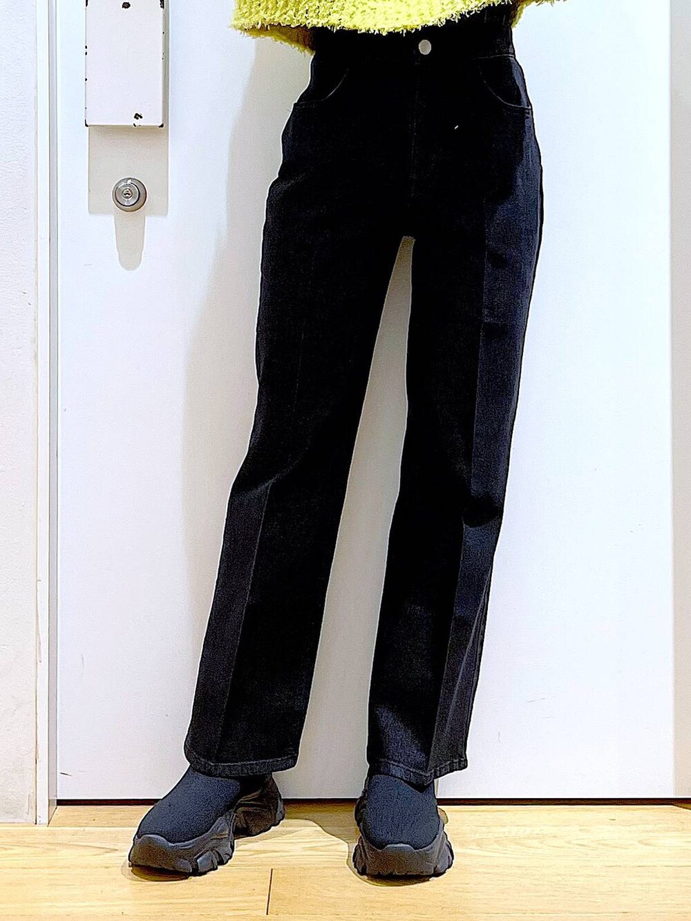 グリーン系のニット/セーター、グレー系のデニムパンツ、シルバー系のショルダーバッグを着用したレディースの冬コーディネートの8枚目の写真