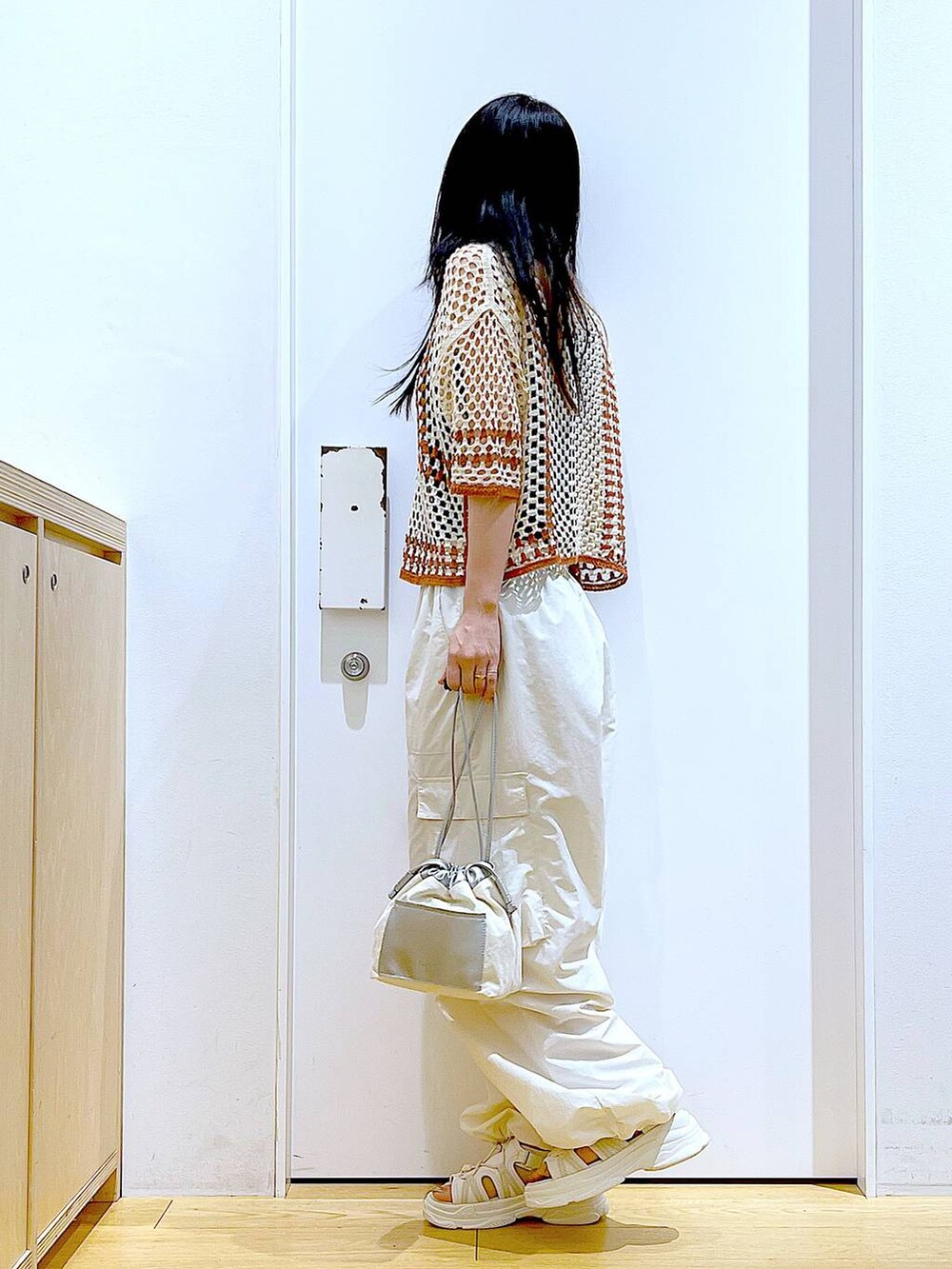 ホワイト系のショルダーバッグ、ホワイト系のカーゴパンツ、ホワイト系のサンダルを着用したレディースの夏コーディネートの3枚目の写真