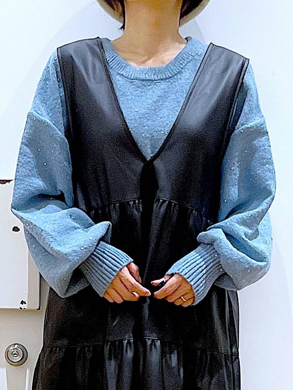 ホワイト系のショルダーバッグ、ブラック系のブーツ、ブラック系のワンピースを着用したレディースの冬コーディネートの7枚目の写真