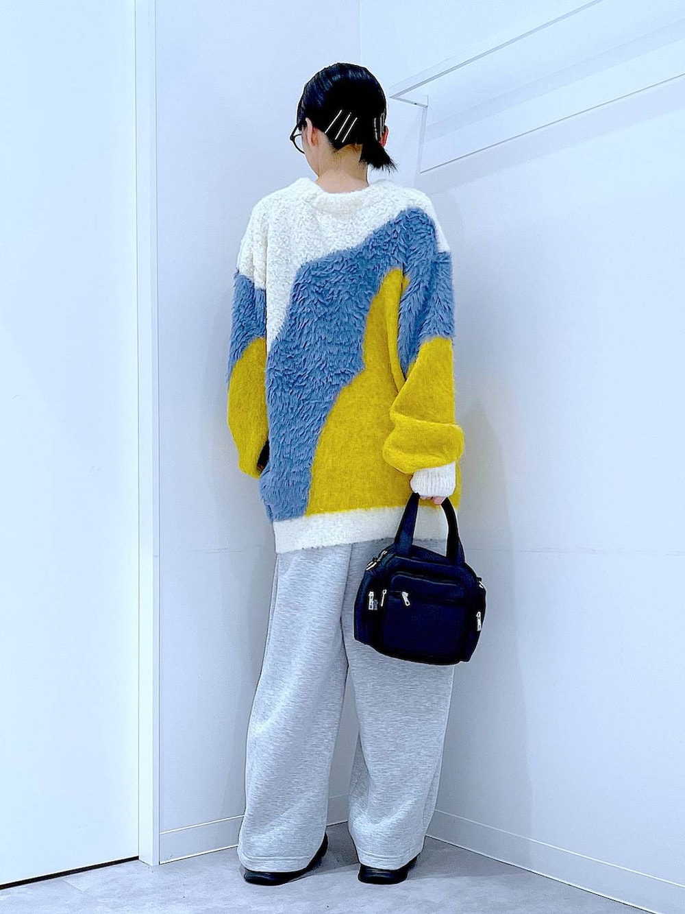 ブラック系のショルダーバッグ、ブラック系のローファー、イエロー系のカーディガン/ボレロを着用したレディースの秋コーディネートの5枚目の写真