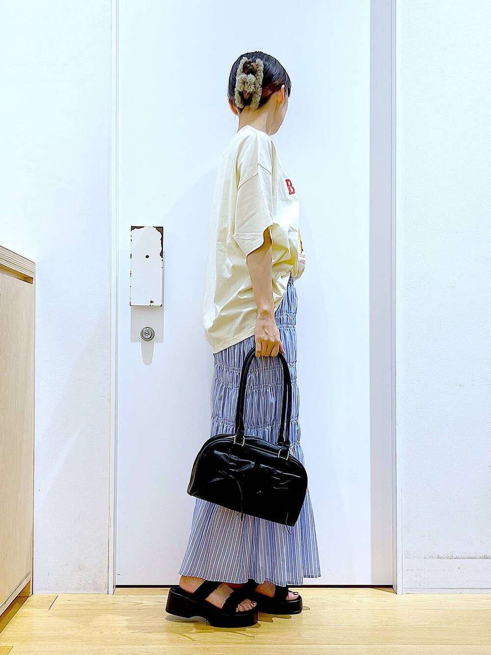 ブラック系のサンダル、その他のスカート、ブラック系のハンドバッグを着用したレディースの夏コーディネートの4枚目の写真