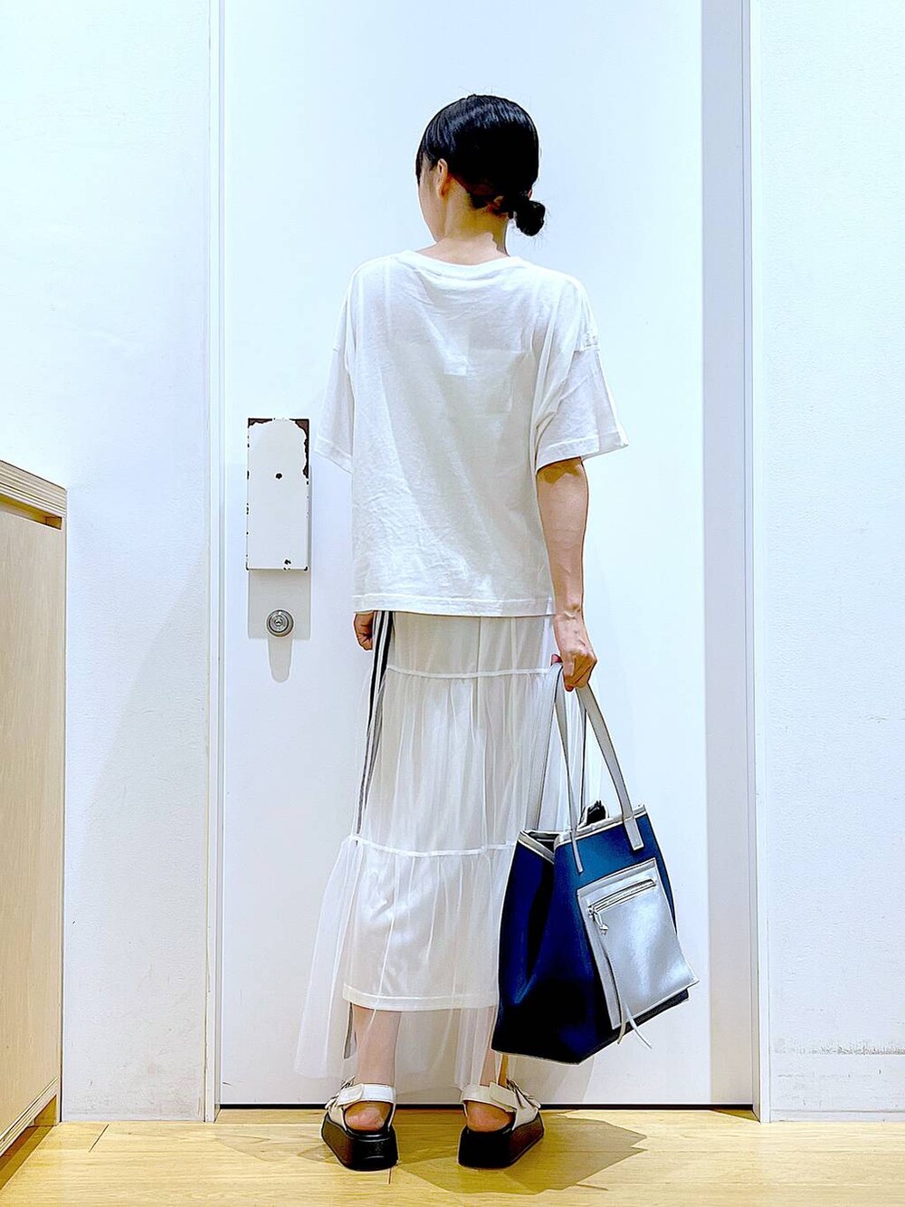 ホワイト系のサンダル、ホワイト系のスカート、ホワイト系のTシャツ/カットソーを着用したレディースの夏コーディネートの5枚目の写真