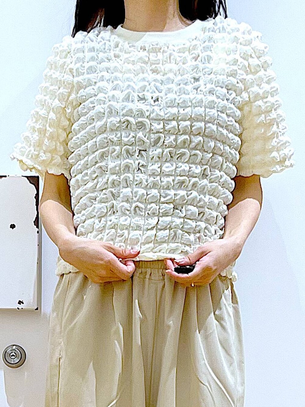 シルバー系のサンダル、ベージュ系のショルダーバッグ、ベージュ系のTシャツ/カットソーを着用したレディースの夏コーディネートの7枚目の写真