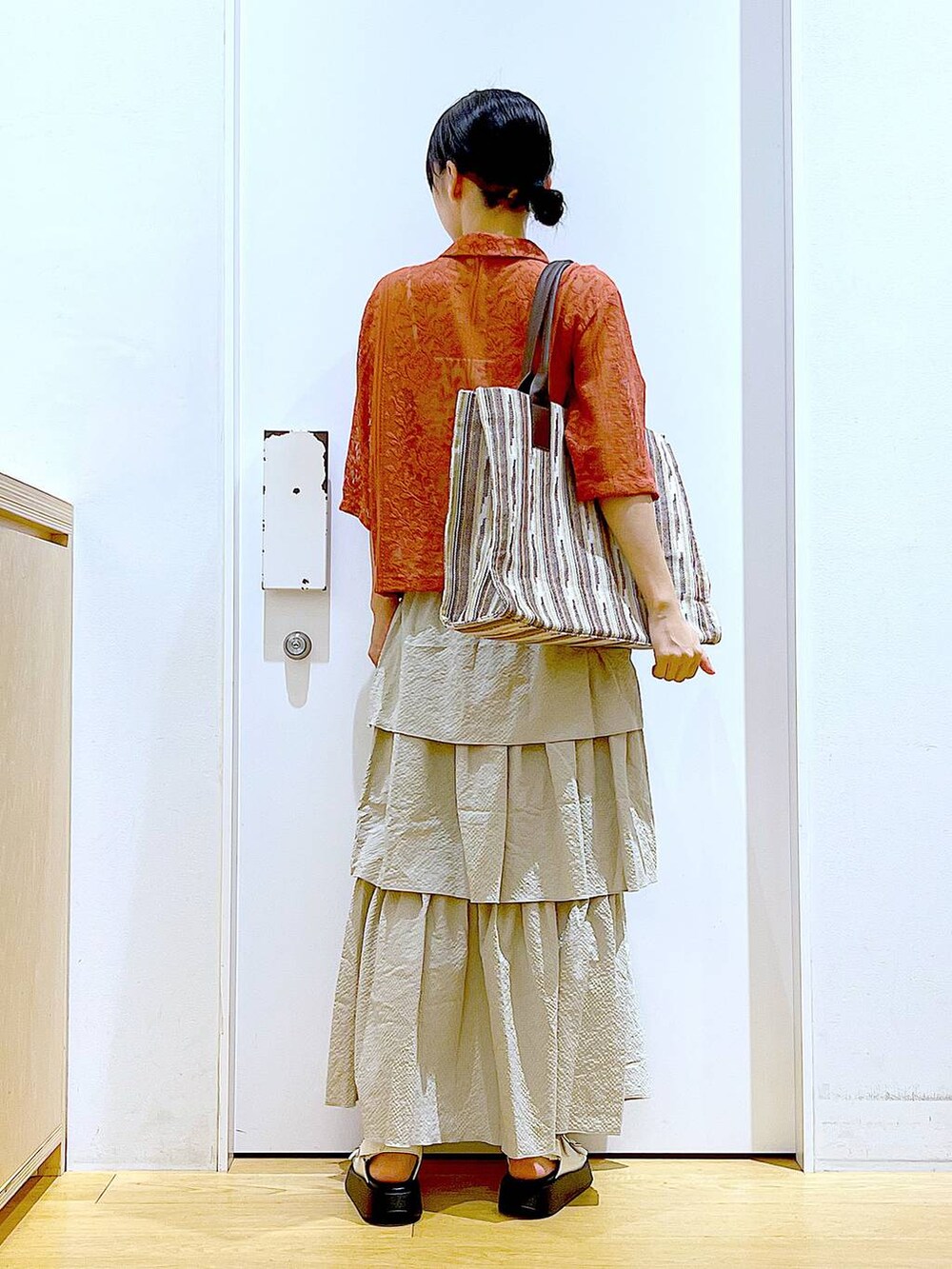 ホワイト系のサンダル、ベージュ系のスカート、レッド系のシャツ/ブラウスを着用したレディースの夏コーディネートの5枚目の写真