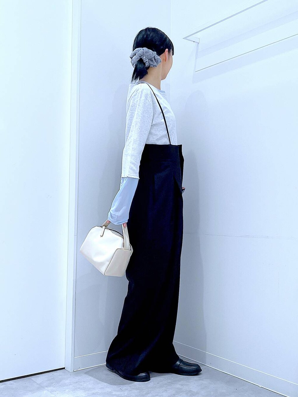 ホワイト系のショルダーバッグ、ブラック系のローファー、ブラック系のサロペット/オーバーオールを着用したレディースの春コーディネートの4枚目の写真