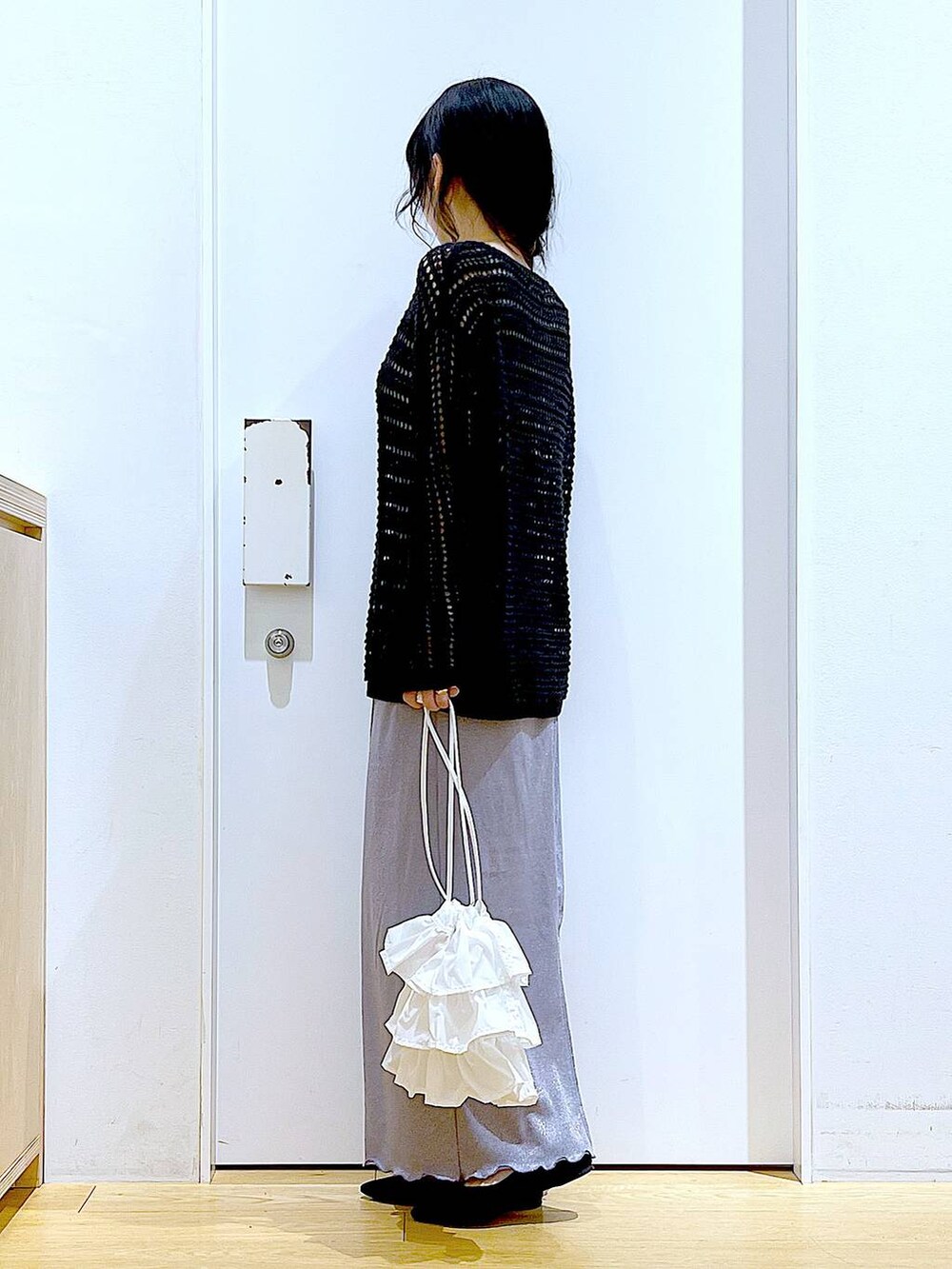 パープル系のスカート、ホワイト系のショルダーバッグ、ブラック系のパンプスを着用したレディースの春コーディネートの3枚目の写真