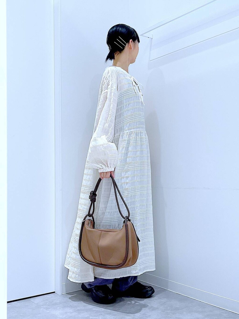 ブラック系のローファー、ブラウン系のショルダーバッグ、ベージュ系のワンピースを着用したレディースの秋コーディネートの4枚目の写真