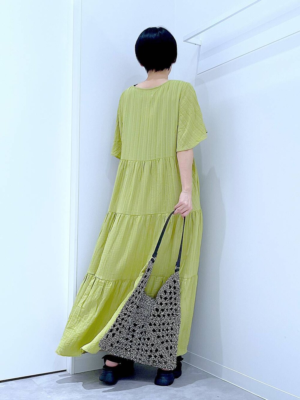 ブラック系のトートバッグ、ブラック系のサンダル、グリーン系のワンピースを着用したレディースの夏コーディネートの5枚目の写真