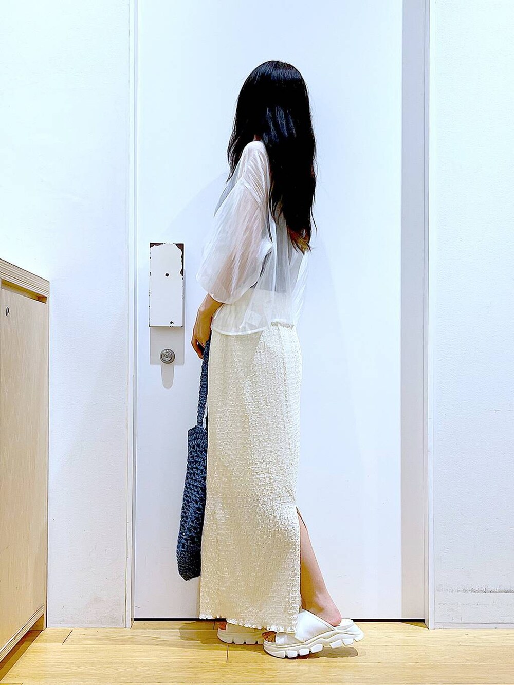 ホワイト系のサンダル、ブラック系のニット/セーター、ブルー系のトートバッグを着用したレディースの夏コーディネートの3枚目の写真