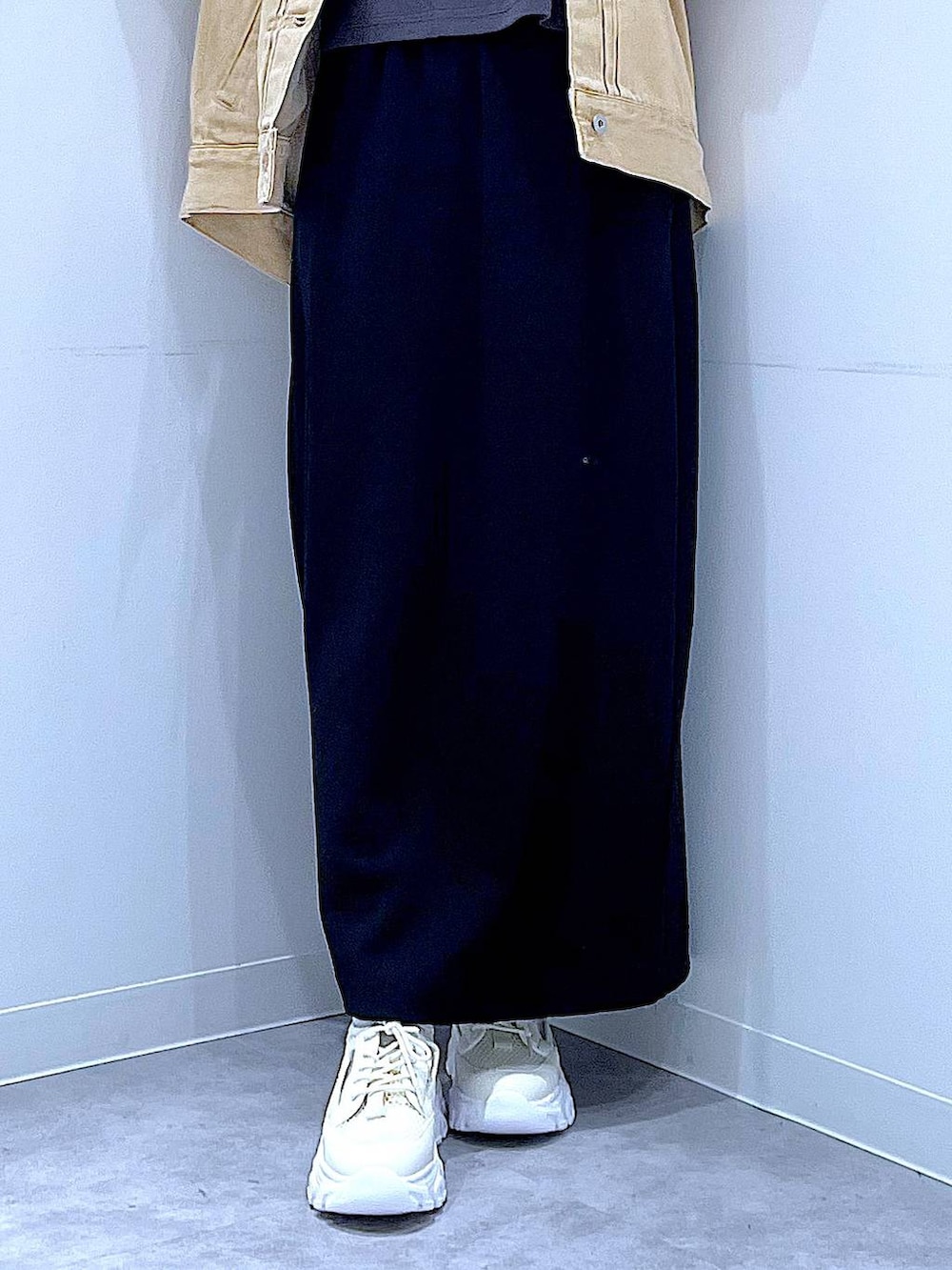 ブラック系のスカート、ベージュ系のデニムジャケット、ブラック系のショルダーバッグを着用したレディースの春コーディネートの8枚目の写真