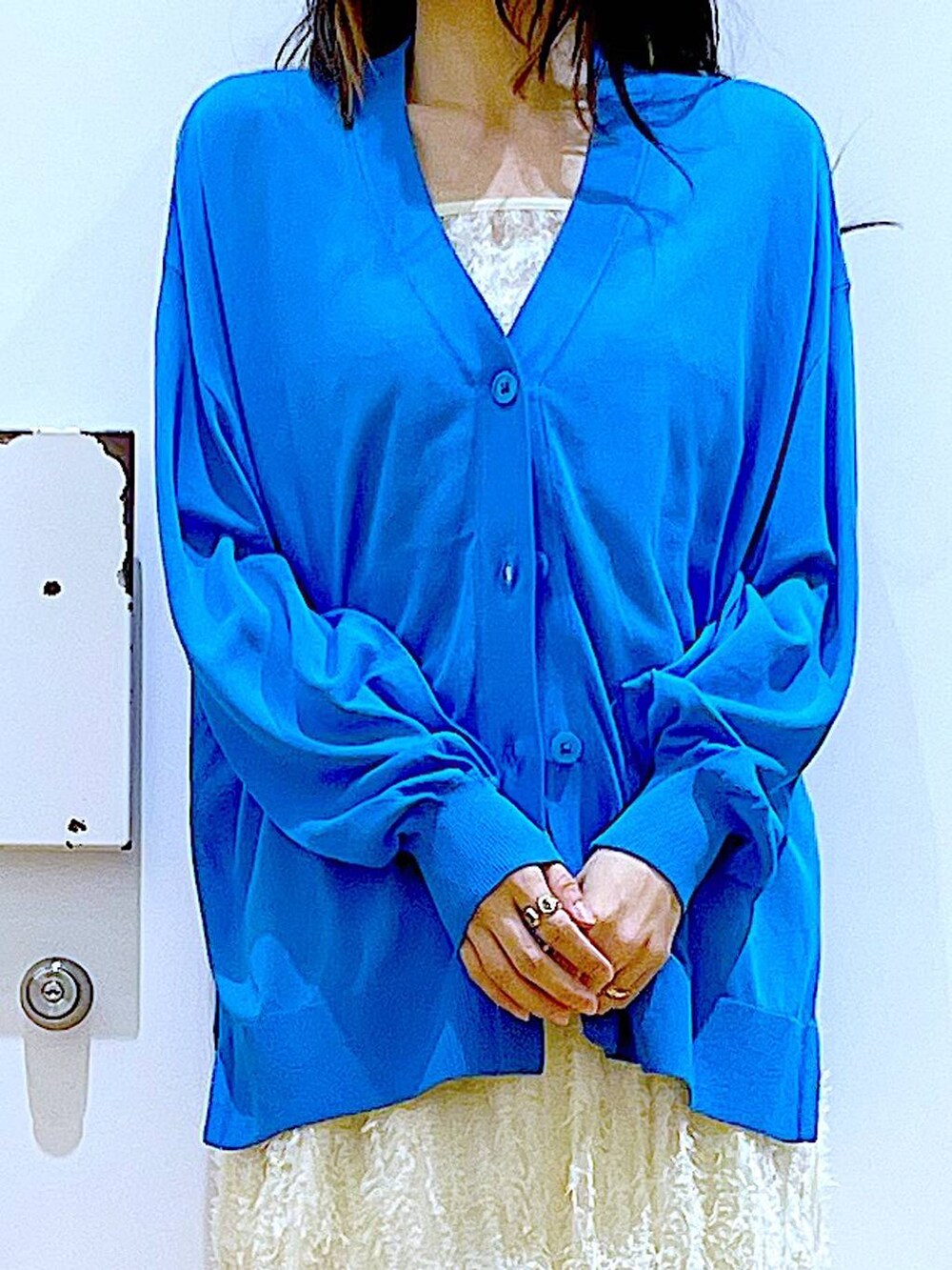 ホワイト系のその他パンツ、ブルー系のカーディガン/ボレロ、ホワイト系のパンプスを着用したレディースの春コーディネートの7枚目の写真