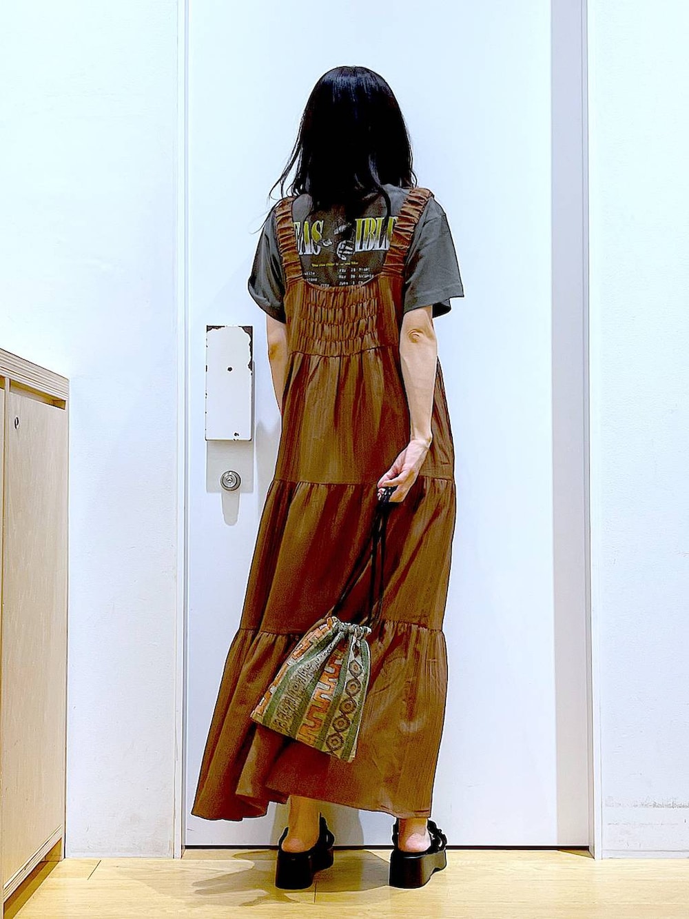 ブラウン系のショルダーバッグ、ブラック系のサンダル、グレー系のTシャツ/カットソーを着用したレディースの夏コーディネートの5枚目の写真