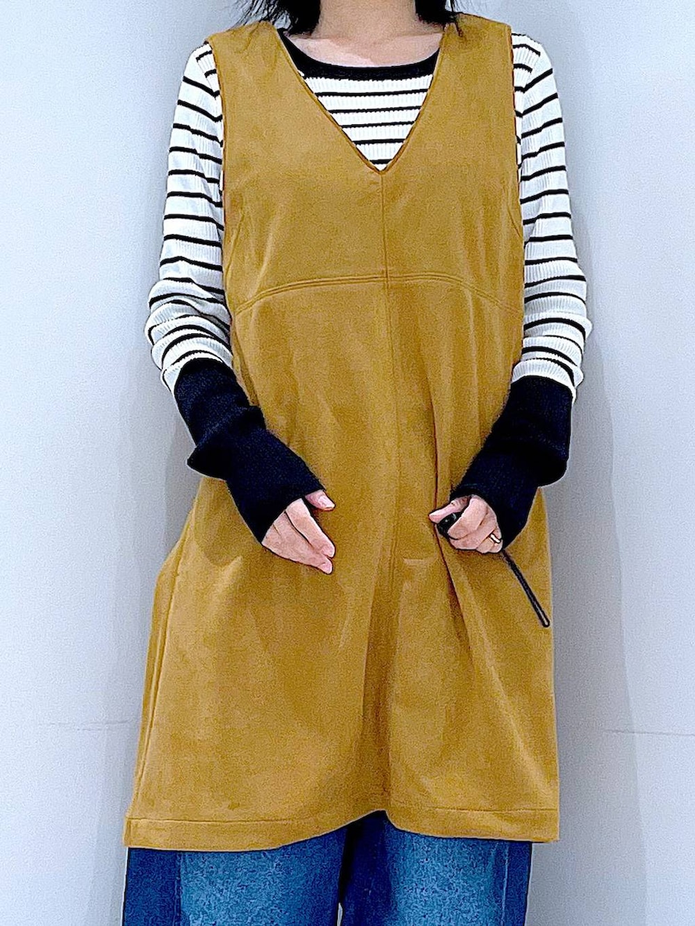 ブラック系のボストンバッグ、ホワイト系のニット/セーター、イエロー系のワンピースを着用したレディースの春コーディネートの7枚目の写真