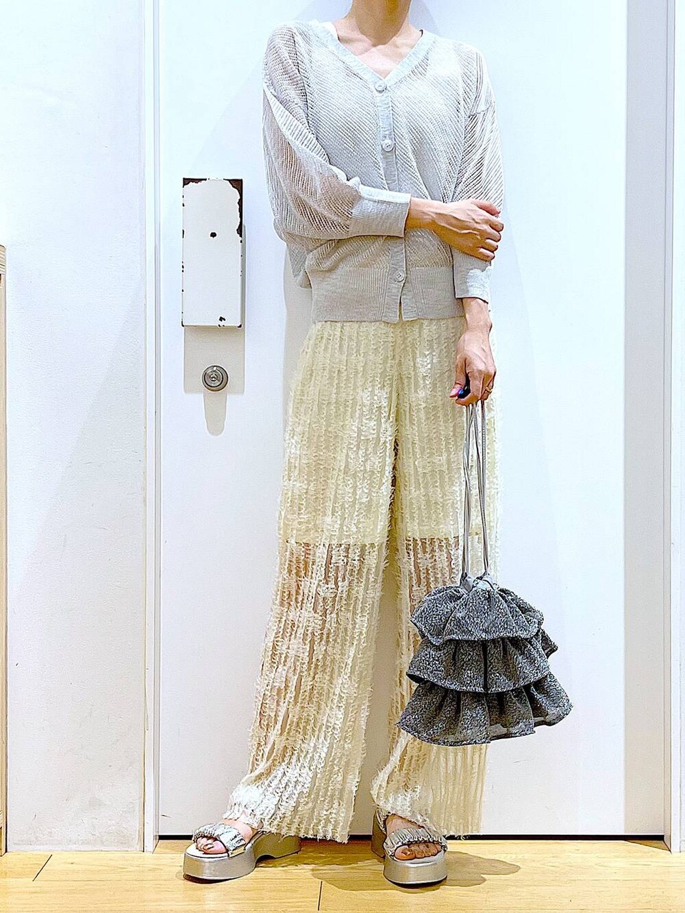 シルバー系のショルダーバッグ、ホワイト系のニット/セーター、ホワイト系のその他パンツを着用したレディースの夏コーディネートの6枚目の写真