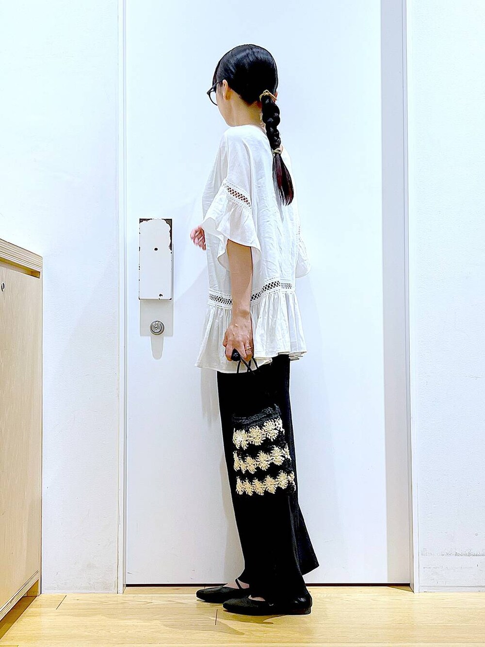 ホワイト系のチュニック、ブラック系のその他パンツ、ブラック系のパンプスを着用したレディースの夏コーディネートの3枚目の写真