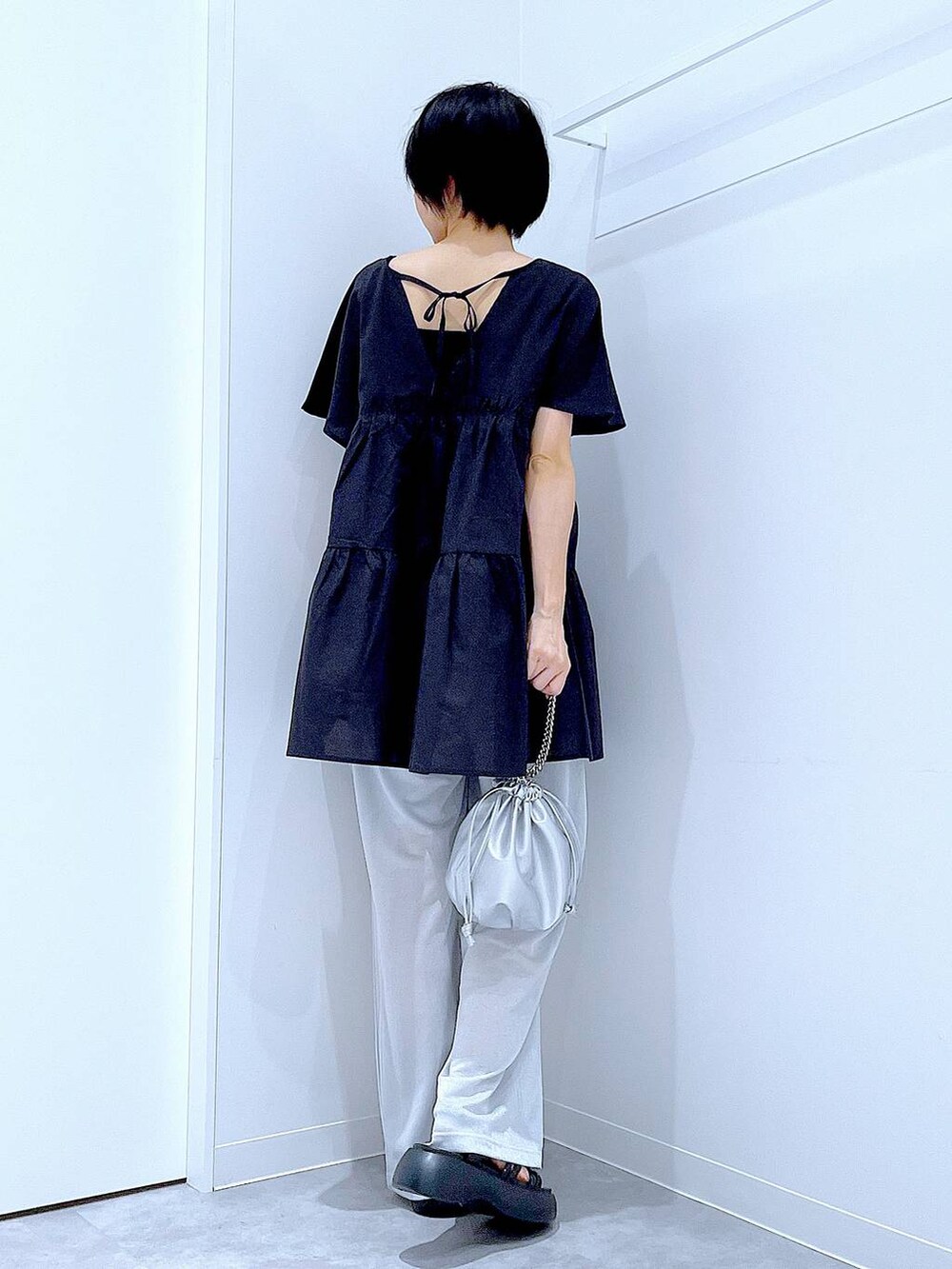 シルバー系のショルダーバッグ、ブラック系のサンダル、グレー系のその他パンツを着用したレディースの夏コーディネートの4枚目の写真