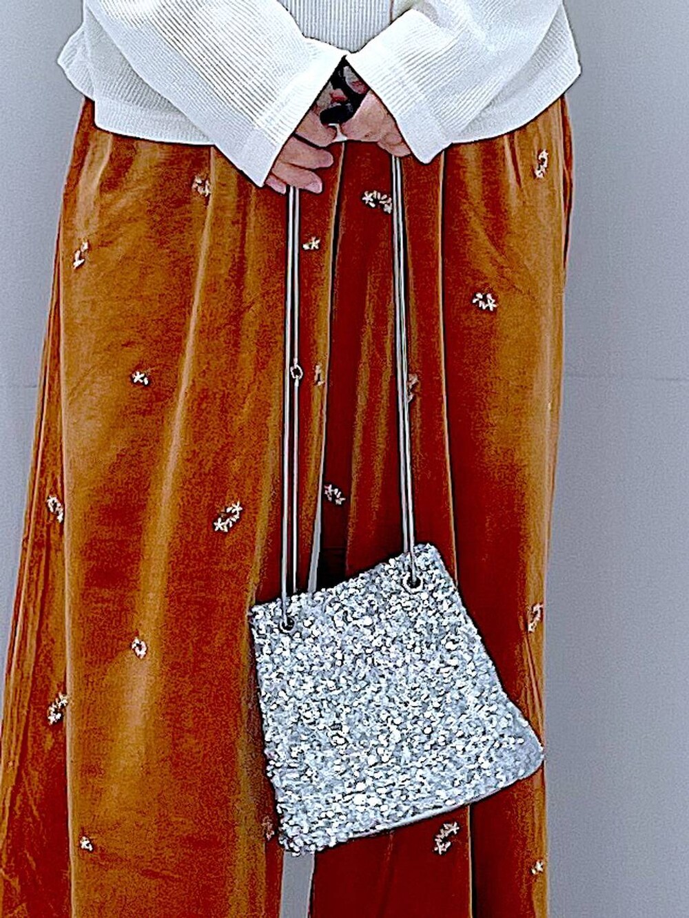 シルバー系のショルダーバッグ、ブラック系のローファー、ベージュ系のTシャツ/カットソーを着用したレディースの秋コーディネートの9枚目の写真