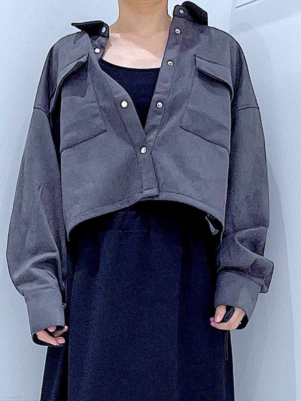 ブラック系のスカート、ブラック系のブーツ、グレー系のシャツ/ブラウスを着用したレディースの秋コーディネートの7枚目の写真