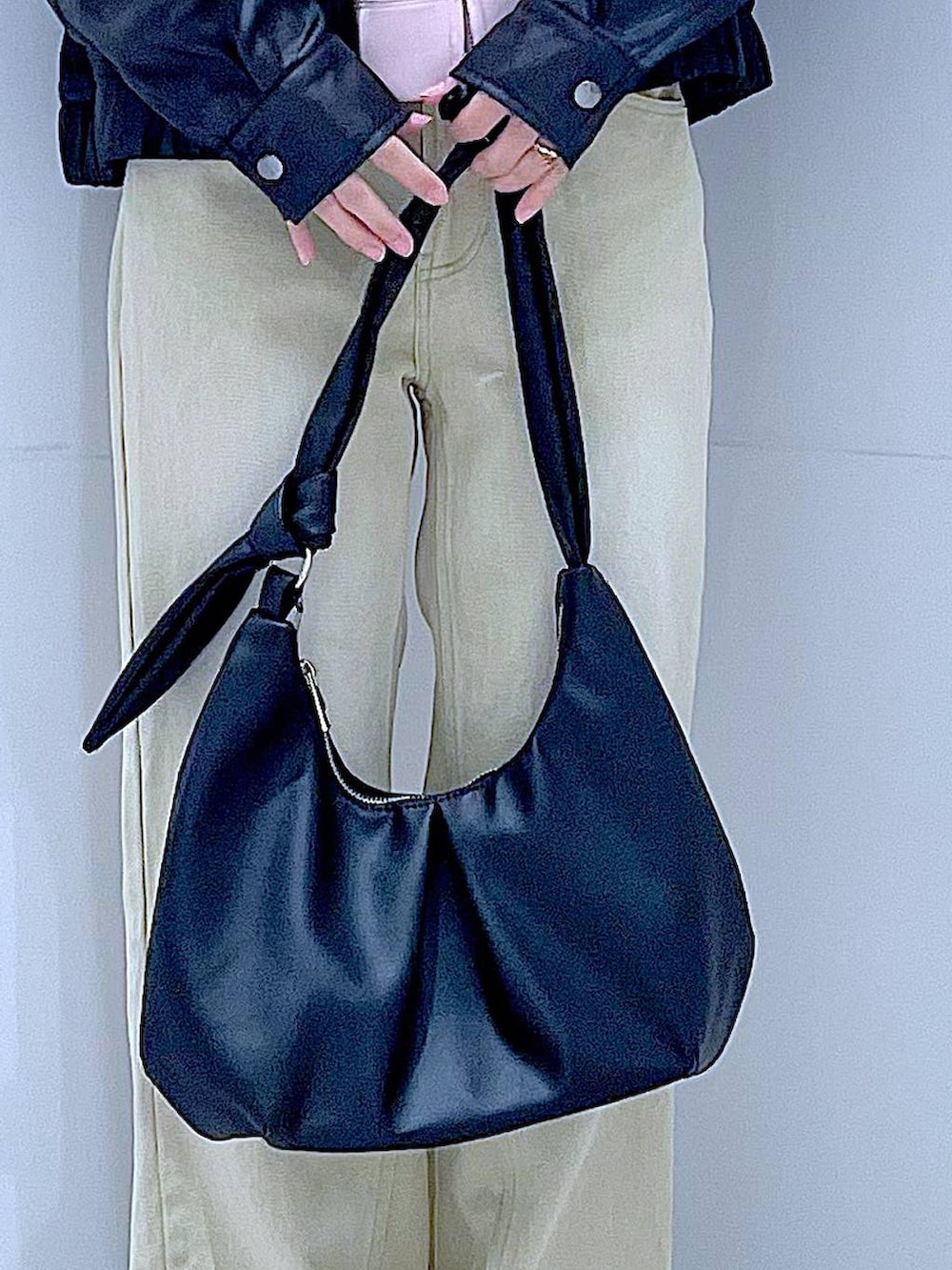 ブラック系のブルゾン、ベージュ系のデニムパンツ、ピンク系のパーカーを着用したレディースの冬コーディネートの9枚目の写真