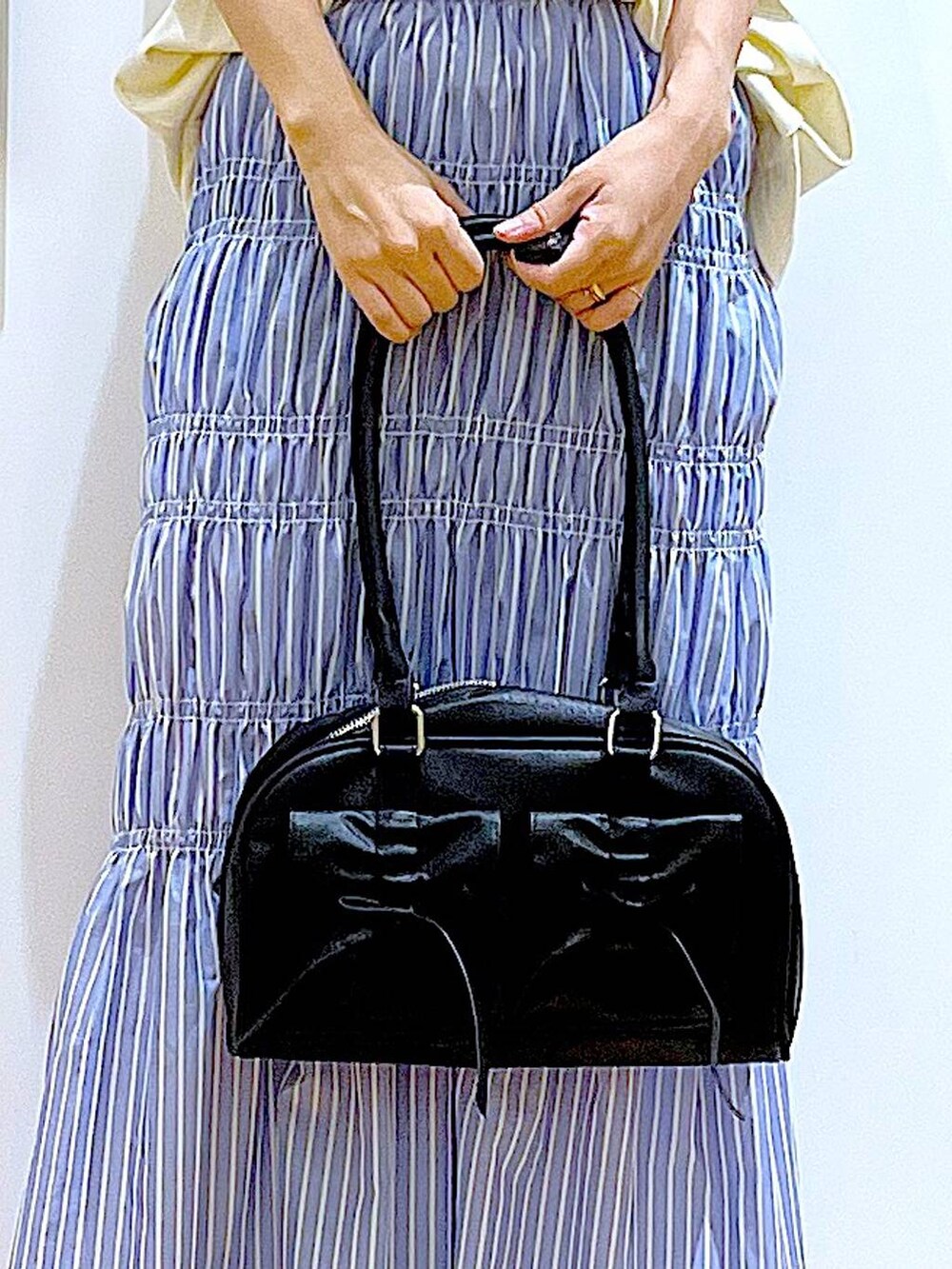 ブラック系のサンダル、その他のスカート、ブラック系のハンドバッグを着用したレディースの夏コーディネートの9枚目の写真