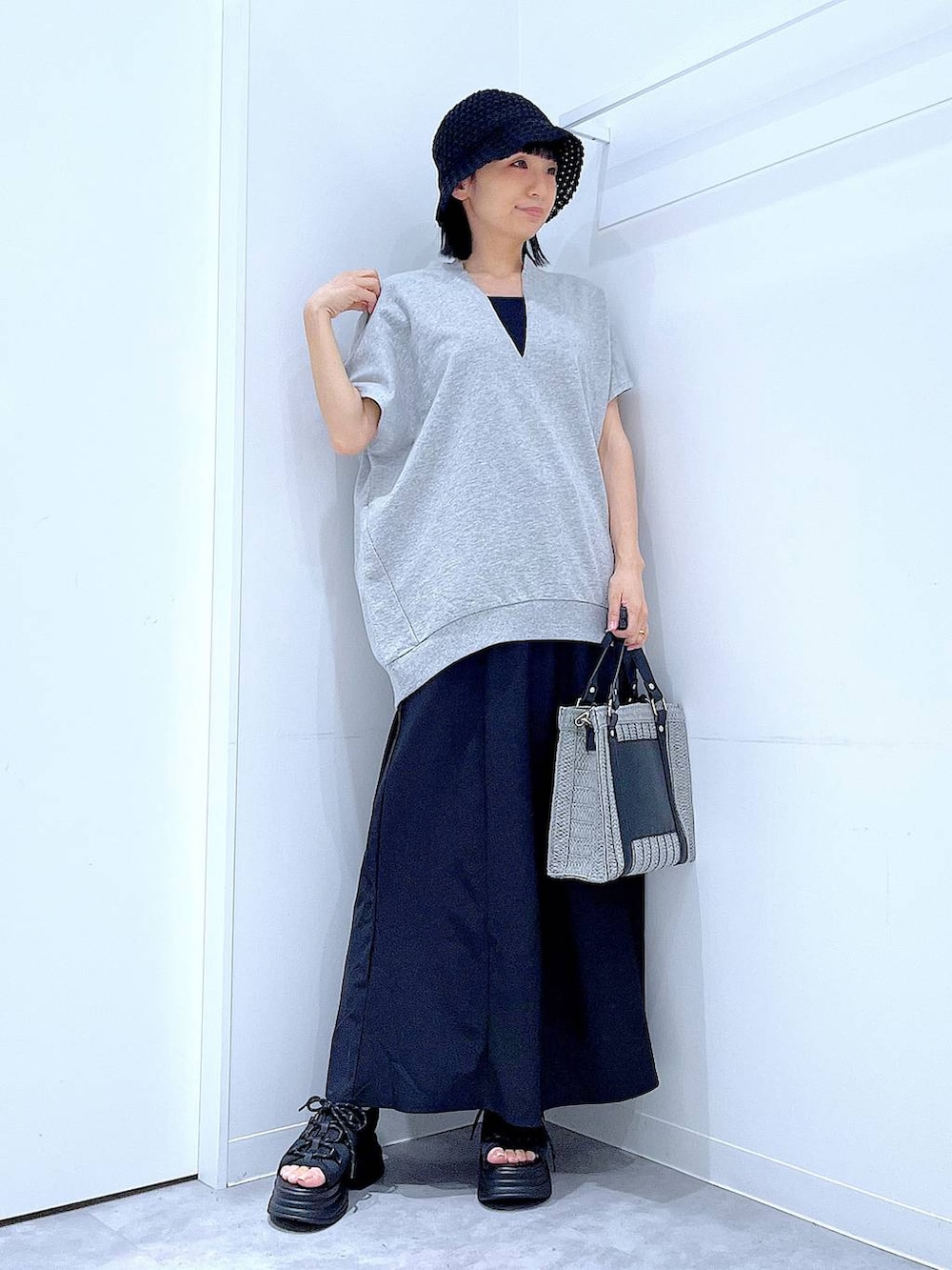 グレー系のショルダーバッグ、ブラック系のサンダル、グレー系のTシャツ/カットソーを着用したレディースの夏コーディネートの2枚目の写真
