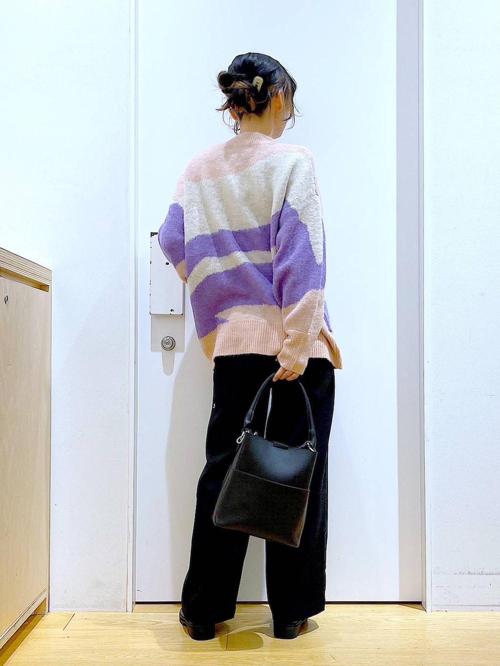 ブラック系のショルダーバッグ、ブラック系のブーツ、ブラック系のニット/セーターを着用したレディースの冬コーディネートの5枚目の写真