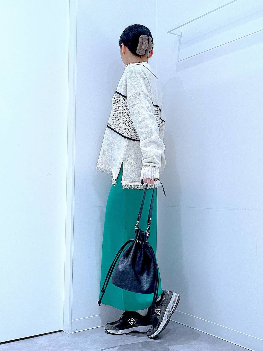 ブラック系のTシャツ/カットソー、グリーン系のスカート、ホワイト系のニット/セーターを着用したレディースの冬コーディネートの3枚目の写真