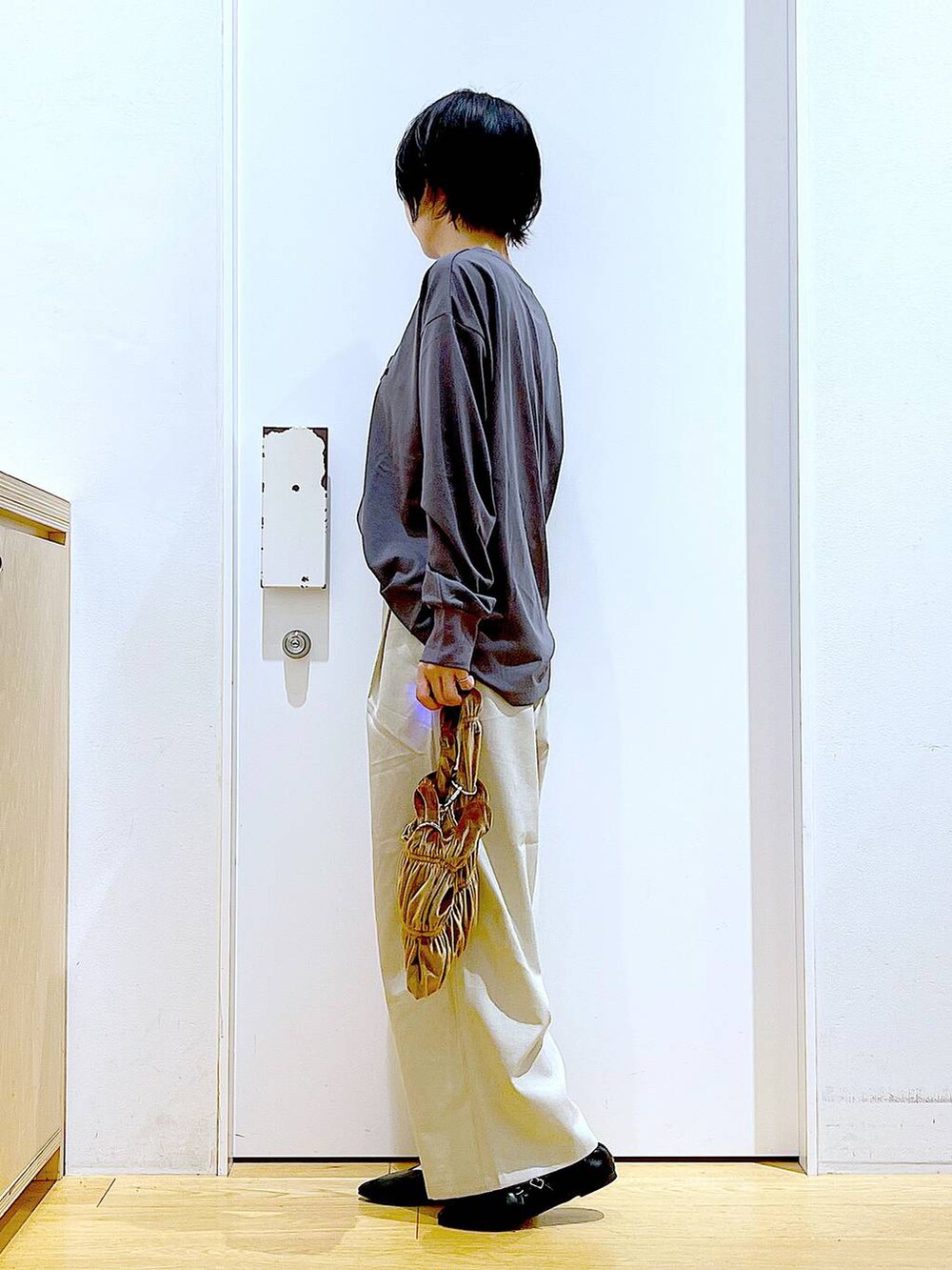 ブラック系のパンプス、イエロー系のショルダーバッグ、ベージュ系のその他パンツを着用したレディースの秋コーディネートの3枚目の写真