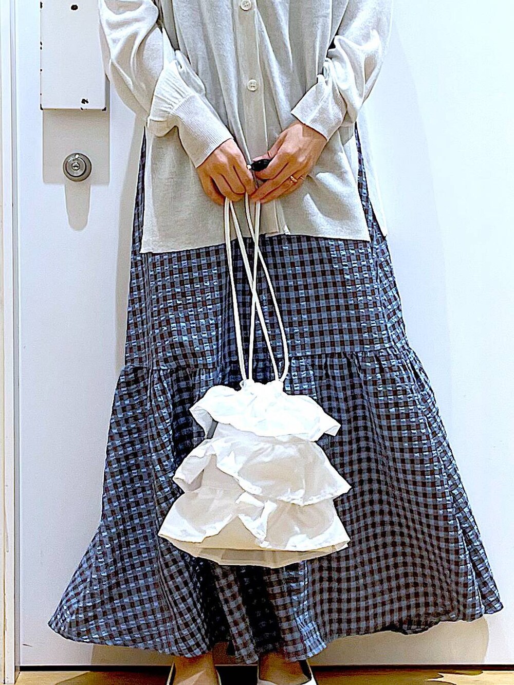 ホワイト系のショルダーバッグ、ブルー系のワンピース、ホワイト系のパンプスを着用したレディースの春コーディネートの9枚目の写真