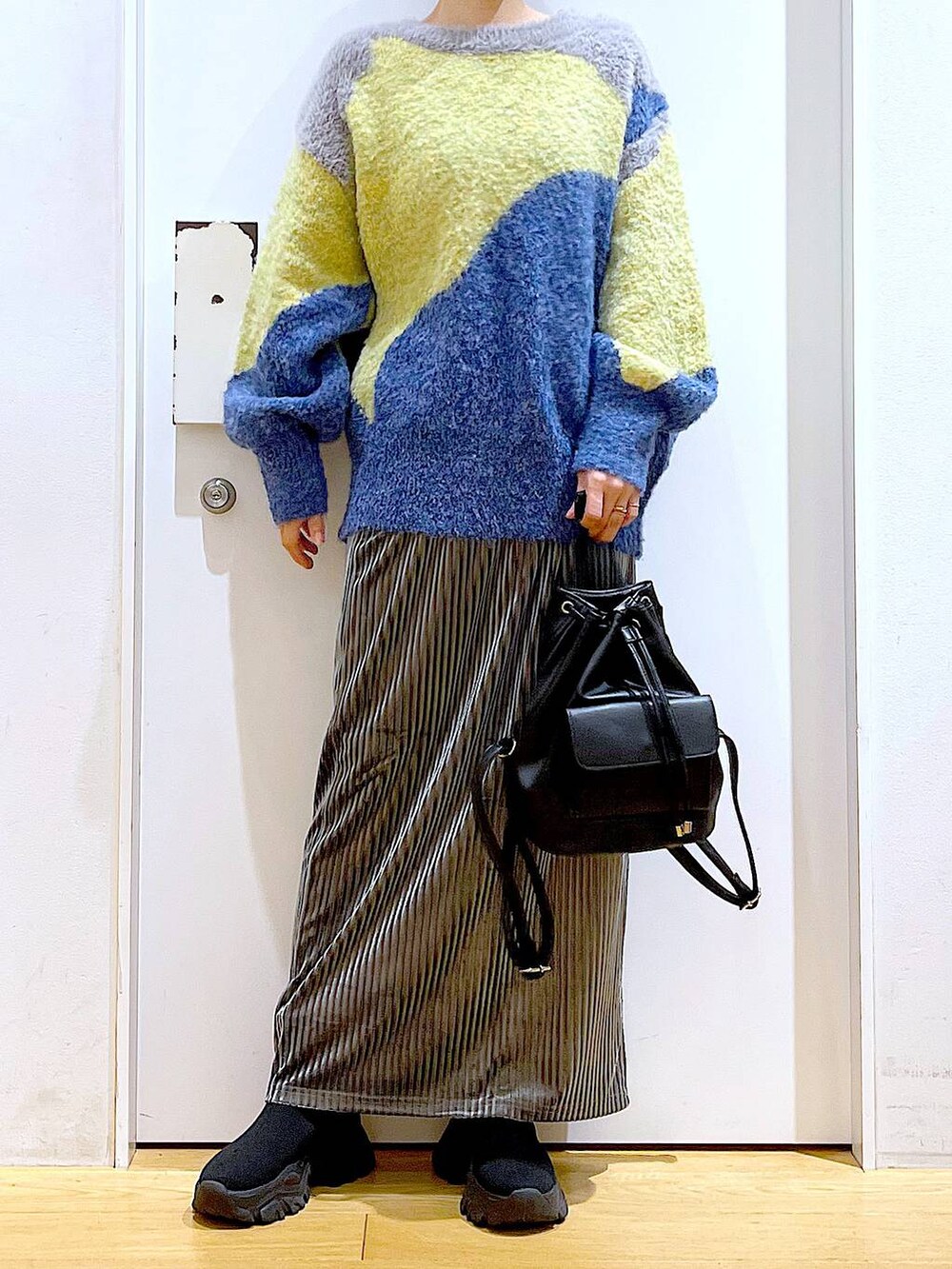 ブラック系のバックパック/リュック、グレー系のスカート、ブラック系のブーツを着用したレディースの冬コーディネートの6枚目の写真