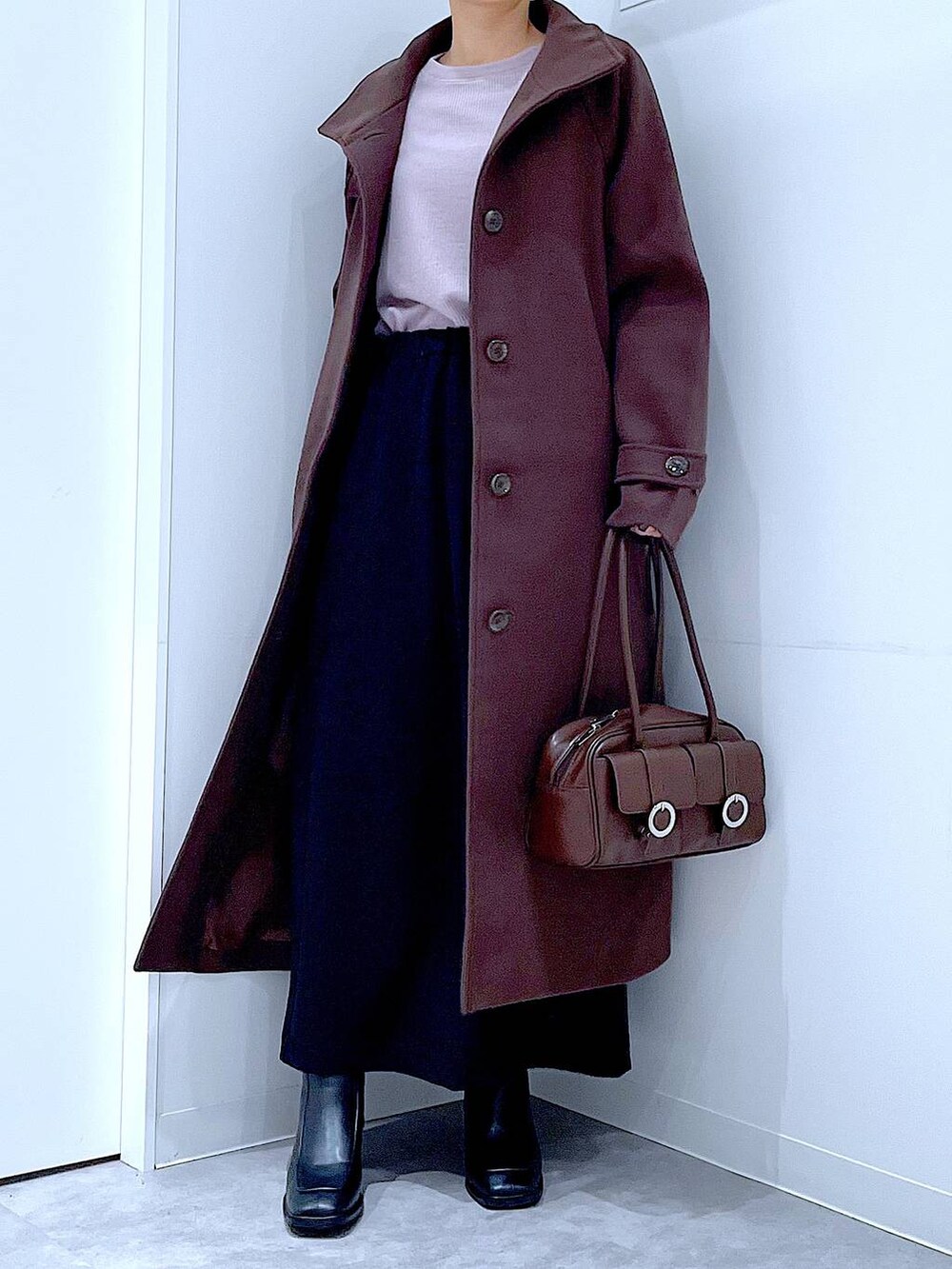 ブラウン系のその他アウター、ブラウン系のショルダーバッグ、ブラック系のスカートを着用したレディースの冬コーディネートの6枚目の写真