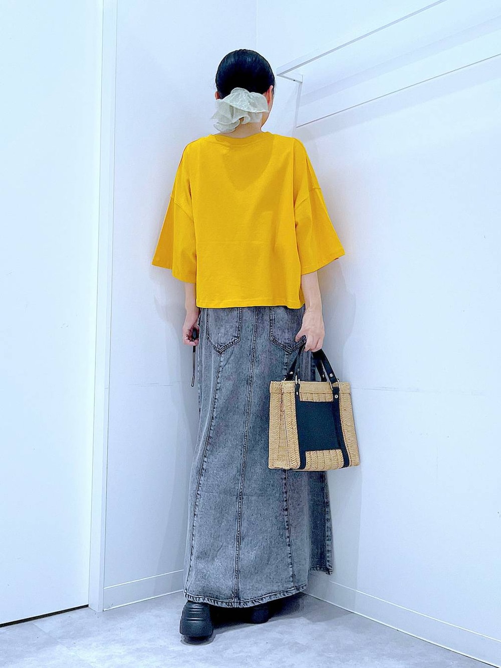 ベージュ系のショルダーバッグ、ブラック系のサンダル、オレンジ系のTシャツ/カットソーを着用したレディースの夏コーディネートの5枚目の写真