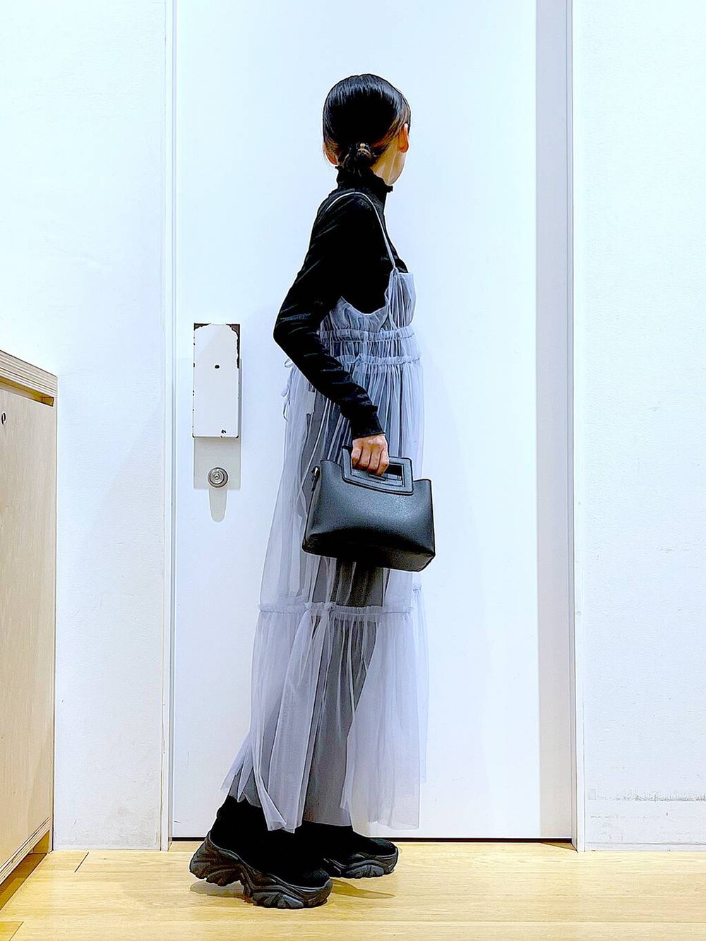 グレー系のデニムパンツ、ブルー系のワンピース、ブラック系のTシャツ/カットソーを着用したレディースの春コーディネートの4枚目の写真