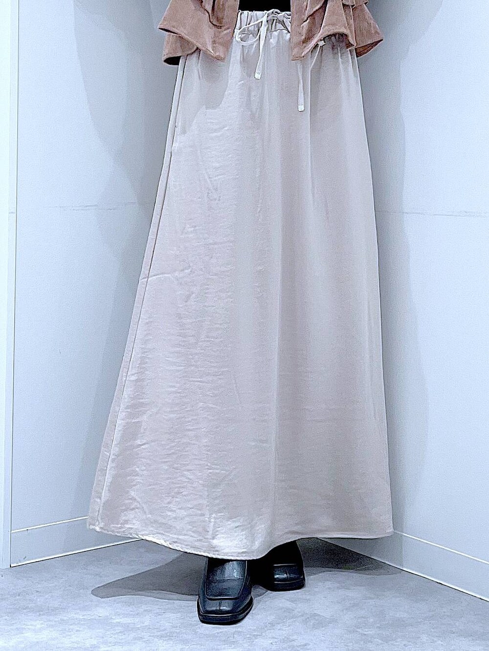 ベージュ系のスカート、ホワイト系のショルダーバッグ、ブラック系のブーツを着用したレディースの秋コーディネートの8枚目の写真