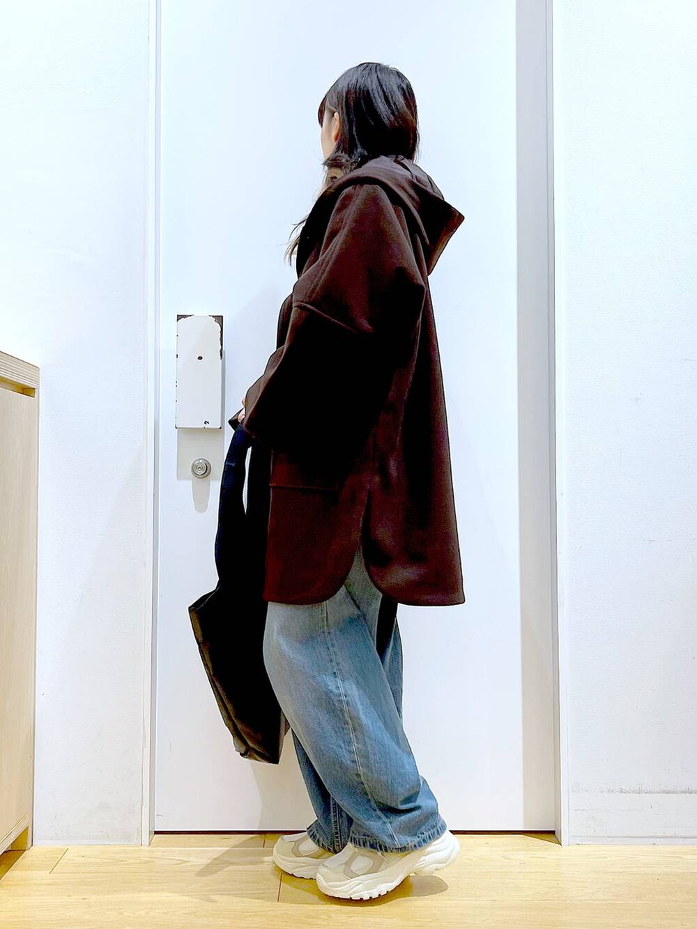 ブラウン系のその他アウター、ベージュ系のスニーカー、ブルー系のデニムパンツを着用したレディースの冬コーディネートの3枚目の写真